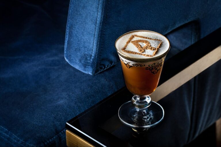 a glass with brown liquid and brown foam