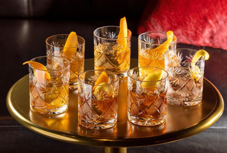 a group of glasses with liquid and lemon slices on a table